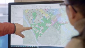 Man pointing to computer screen showing plans
